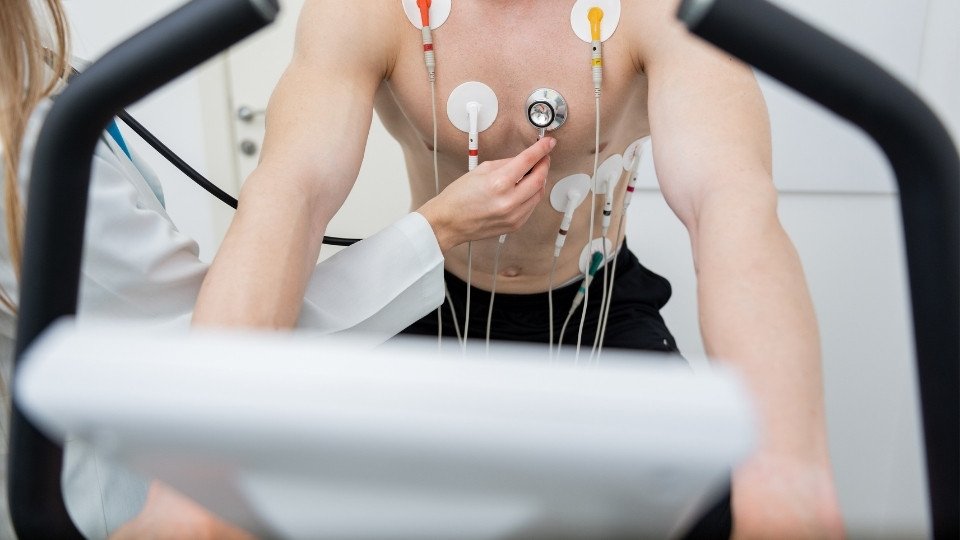 Prueba de esfuerzo paciente con electrodos camina en banda ergométrica supervisada para evaluar capacidad cardiaca