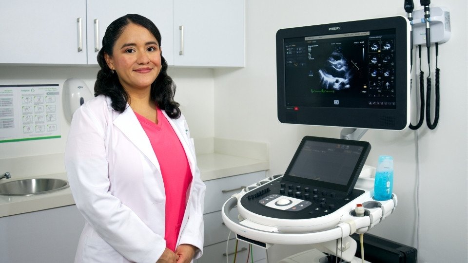 cocardiograma Doppler cardióloga aplica transductor y monitor muestra flujo sanguíneo en tiempo real