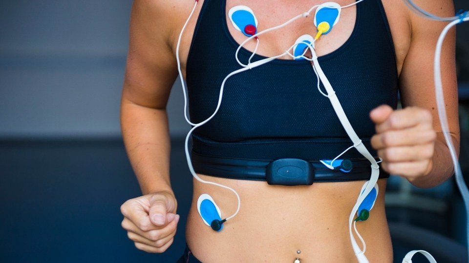 Paciente caminando en banda durante prueba de esfuerzo con monitoreo ECG