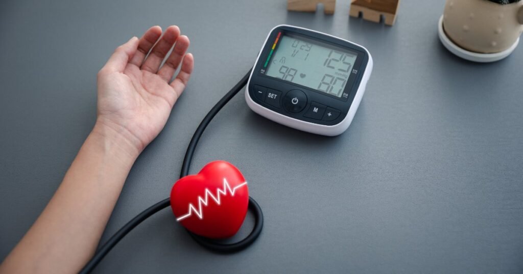 Person measuring blood pressure at home with a blood pressure monitor to control blood pressure goals.